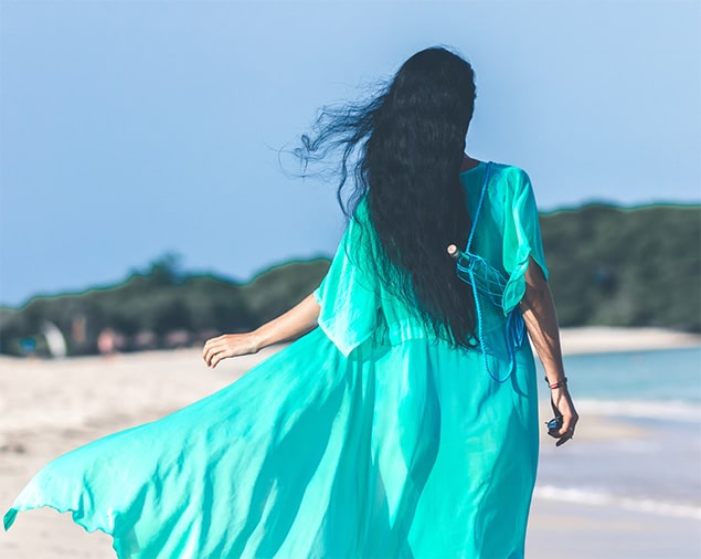 Woman in green dress blowing in the wind